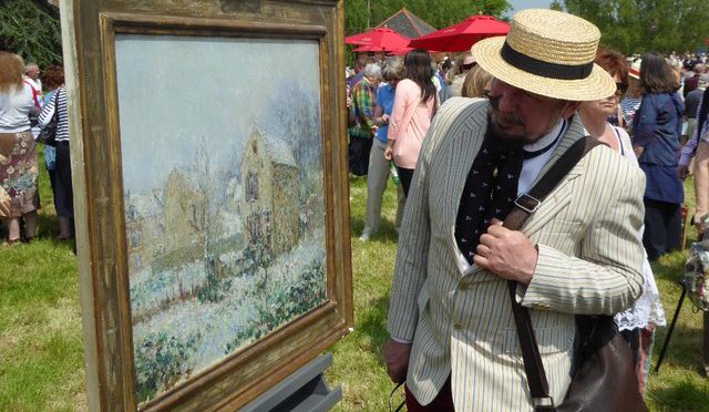 Man looking at fine art painting at antique sale