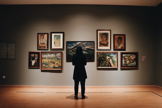 A person admiring valuable art in a gallery